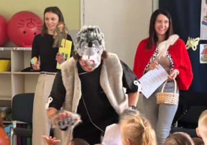 Wilk rozmawia i bawi się z dziećmi podczas przedstawienia.