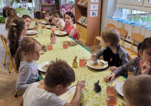 Dzieci siedzą przy stole podczas obiadu wielkanocnego
