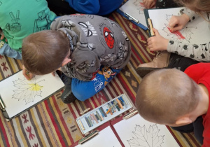 Dzieci z grupy Zające kolorują jesienne liście