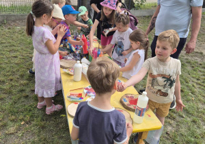 Dzieci malują na drewnie podczas Pikniku