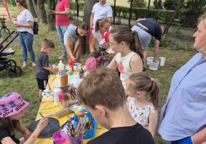 Przedszkolaki malują na drewnie podczas Pikniku