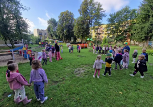 Dzieci na placu przedszkolnym wspólnie śpiewają piosenkę o Kropce.
