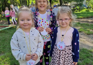 Trzy dziewczynki z uśmiechem na twarzy prezentują swoje kropkowe ordery.