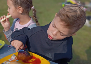 Antoś i Julia jedzą kiełbaski i serek