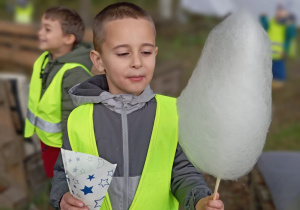 Aleksandr trzyma w rękach popcorn i watę cukrową