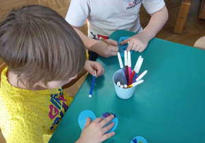 Gabryś i Amelka rysują prawa dziecka na niebieskim serduszku