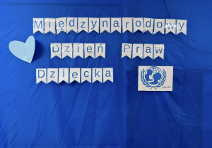 Niebieskie tło z białym napisem Międzynarodowy Dzień Praw Dziecka