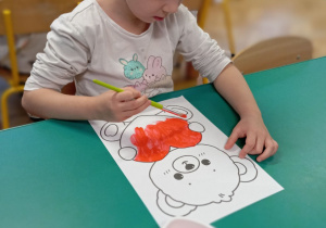 Ewa maluje farbami rysunek misia