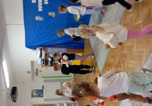 Dzieci tańczą w kole z misiami