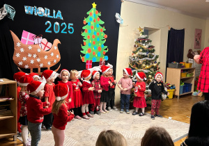 Grupa Zajączków jako mikołaje śpiewają piosenkę