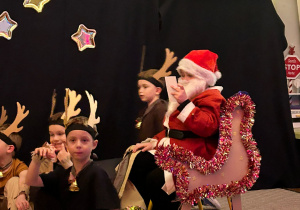 Dzieci z grupy Misiów jako renifery i Mikołaj na sankach