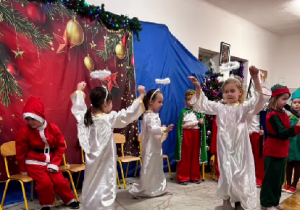 Hania, Ewa i Alicja z grupy Sówki tańczą w strojach aniołków