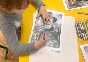 Dziewczynka koloruje kartkę.