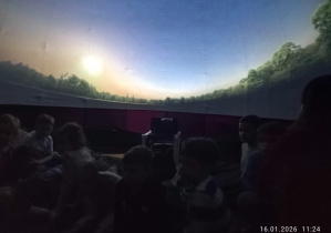 Dzieci siedza na dywanie, oglądając start rakiety