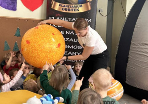 Dzieci oglądają duży balon jako słońce