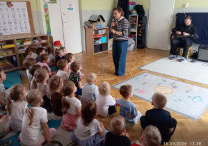 Dzieci słuchają Pani Muzyki, która opowiada o nowych instrumencie .