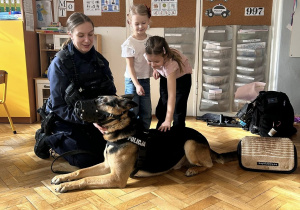Lenka i Nela pod opieką Pani Policjantki uczą się jak bezpiecznie podchodzić do psa.