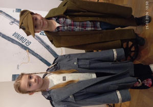 Dwoje dzieci przymierza historyczne mundury wojskowe