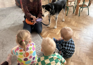 Dzieci siedzą w kręgu, słuchają opowieści o psie.