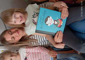 Tosia na kolanach swojej mamy trzyma w ręku tytułową ksiązkę.