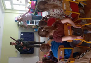 Dzieci siedzą i słuchają prezentacji fagotu prowadzonej przez muzyka oraz Panią Muzykę