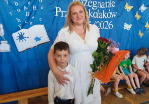 Nauczycielka pozuje do pamiątkowego zdjęcia z przedszkolakiem.