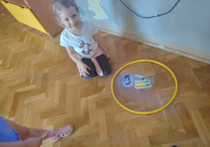 Dziewczynka wykonuje zadanie segregacji śmieci.